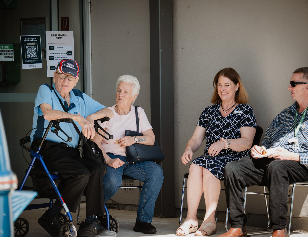 two seniors and two middled age people sitting in the shade